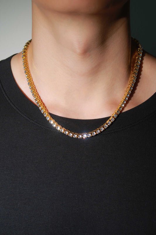Necklace with small stones worn by a person on a plain background